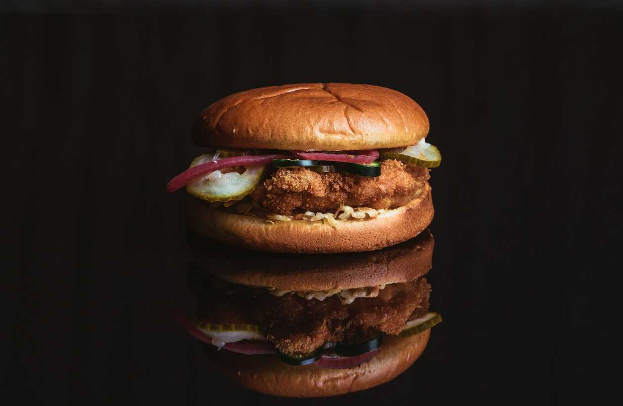 Burger with fried chicken and hot peppers