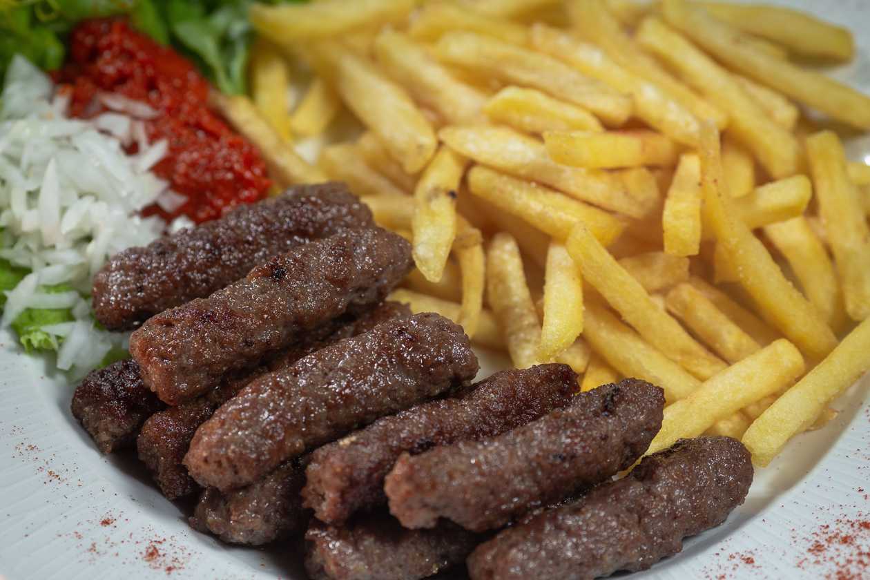 Cevaps with a side dish and a sauce