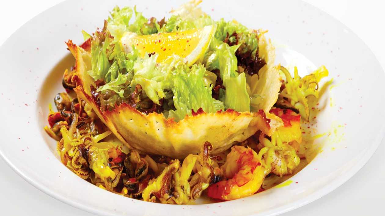 Salad of parmesan cheese basket with seafood
