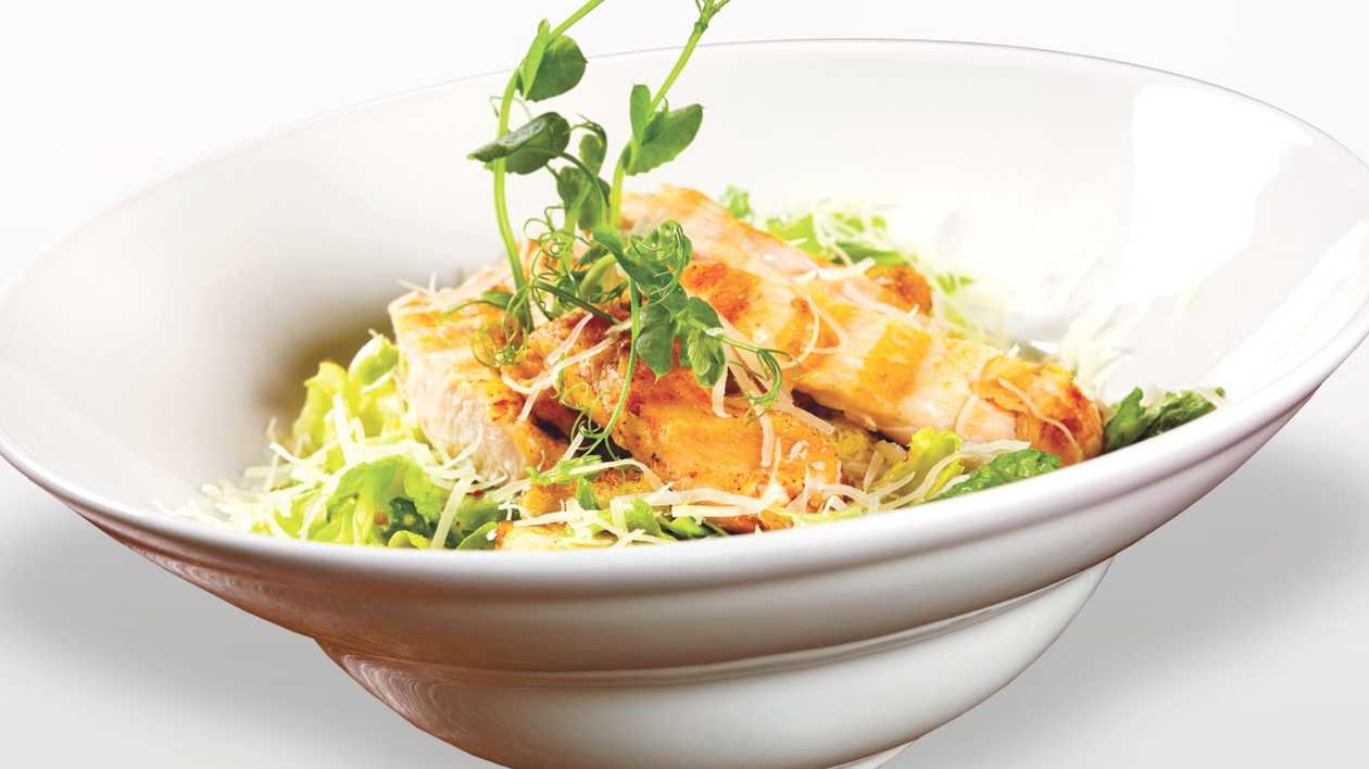 Caesar salad with slices of chicken breast