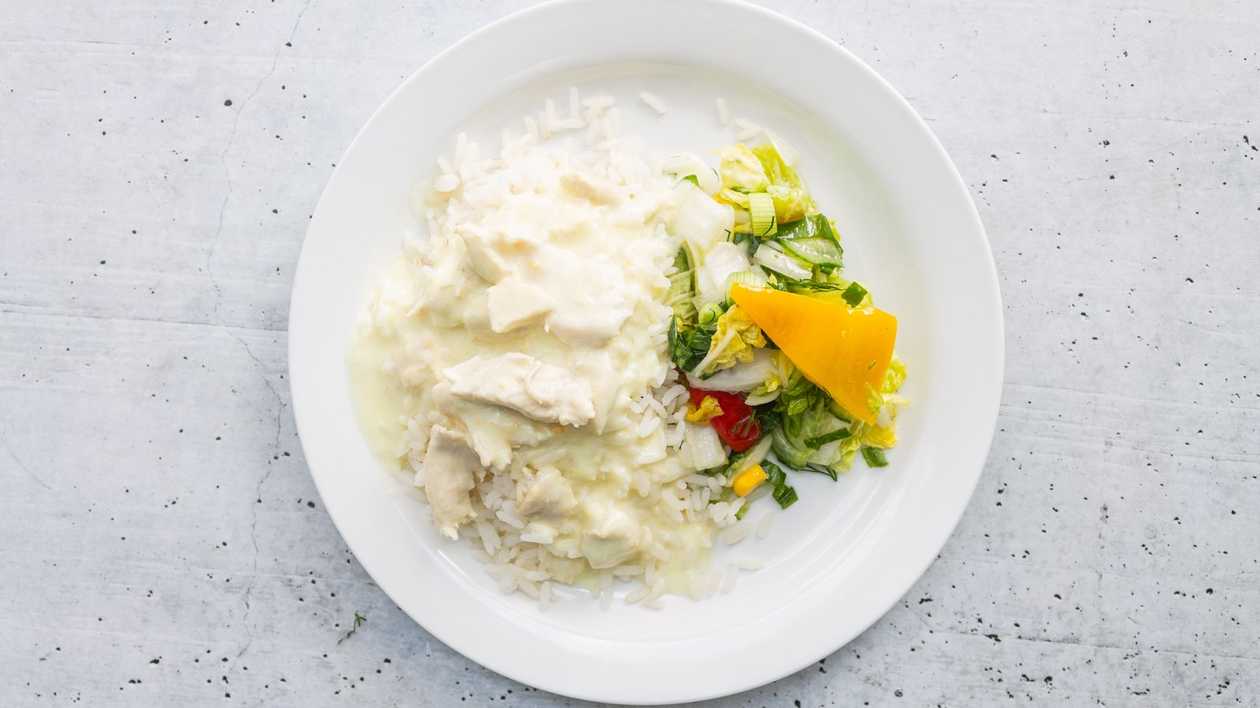 Pieces of chicken fillet in cheese sauce with boiled rice