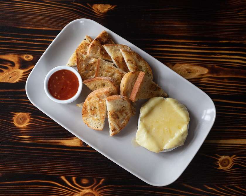 Grilled camembert cheese with sweet chili sauce and toasted baguette