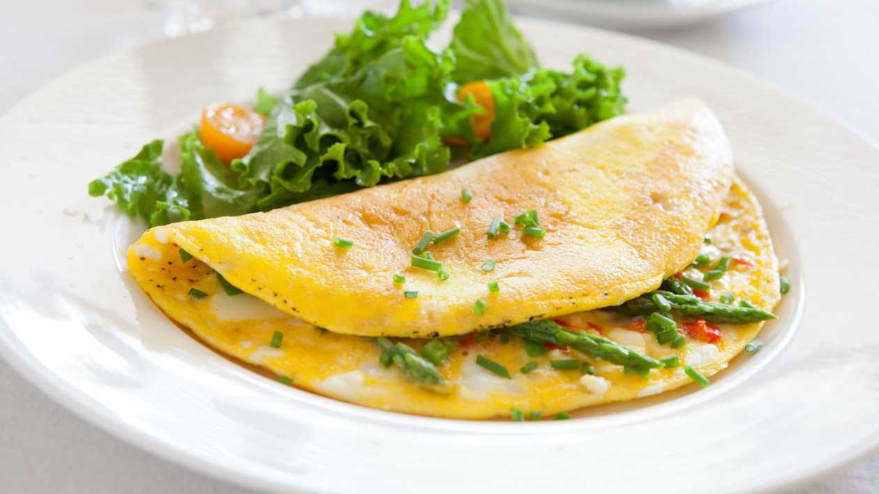 Omelette from 3 eggs with cheese and fresh vegetables