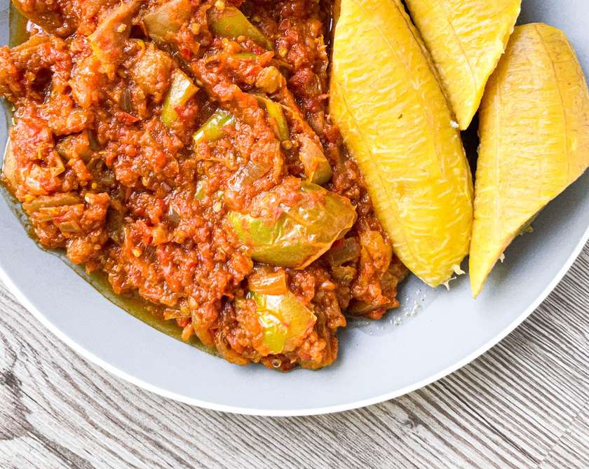 Cooked ripped plantain with vegetables  stew and fried chicken