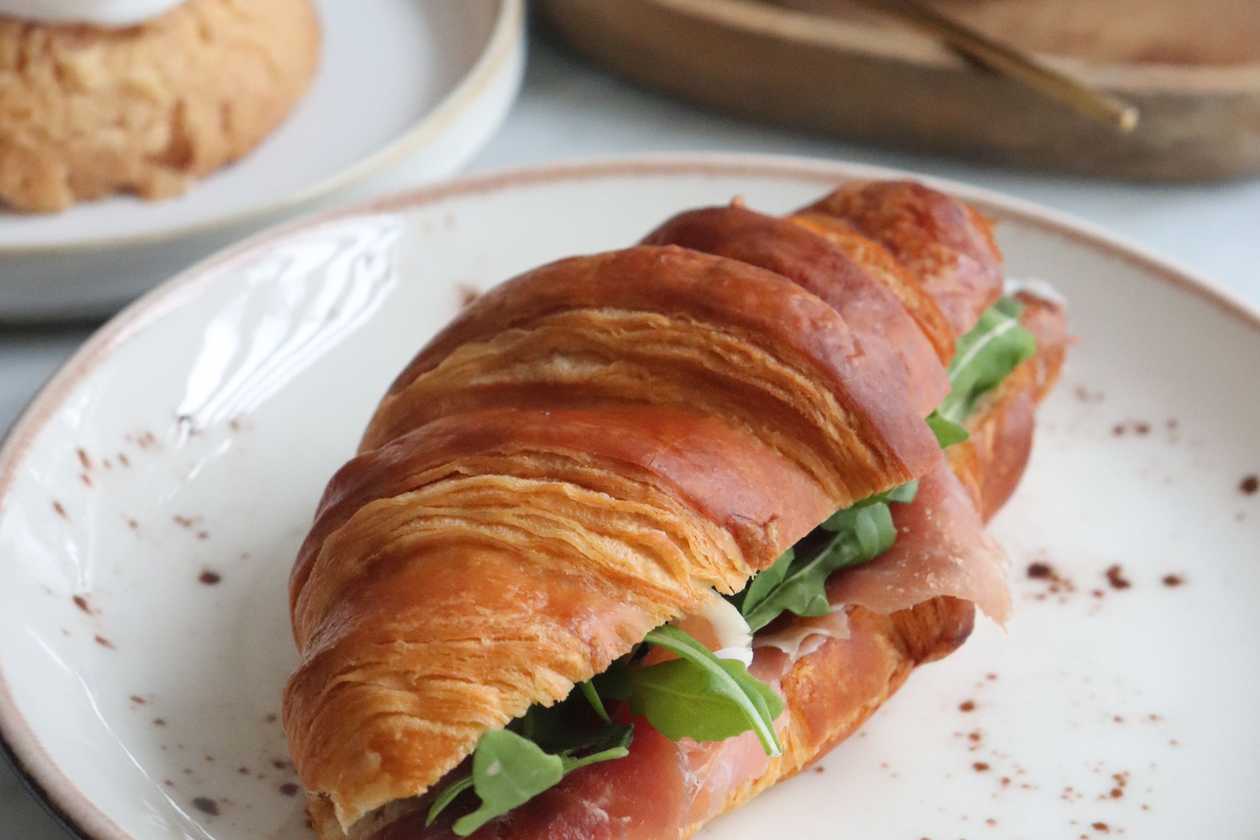 Croissant with brie cheese, ham & arugula
