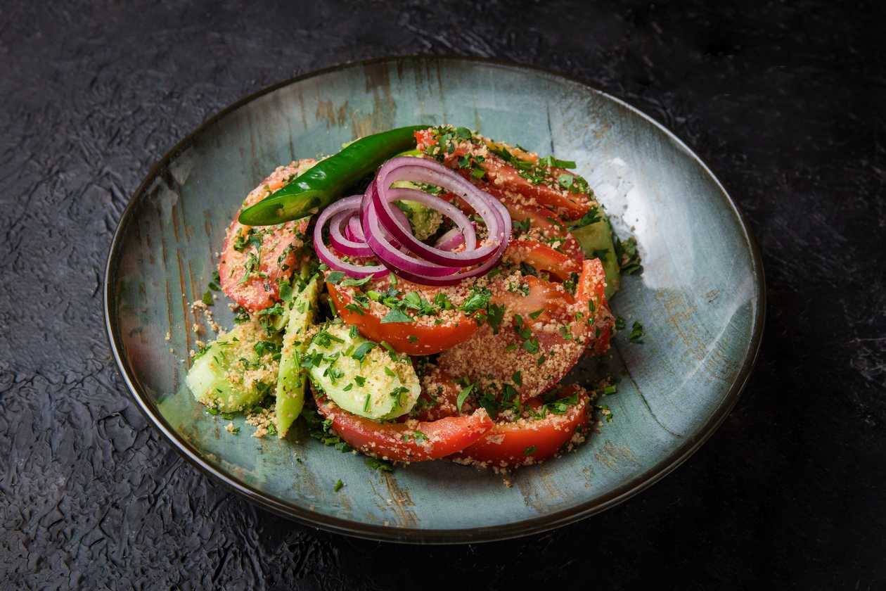 Georgian salad with tomatoes, cucumbers, walnuts and greens