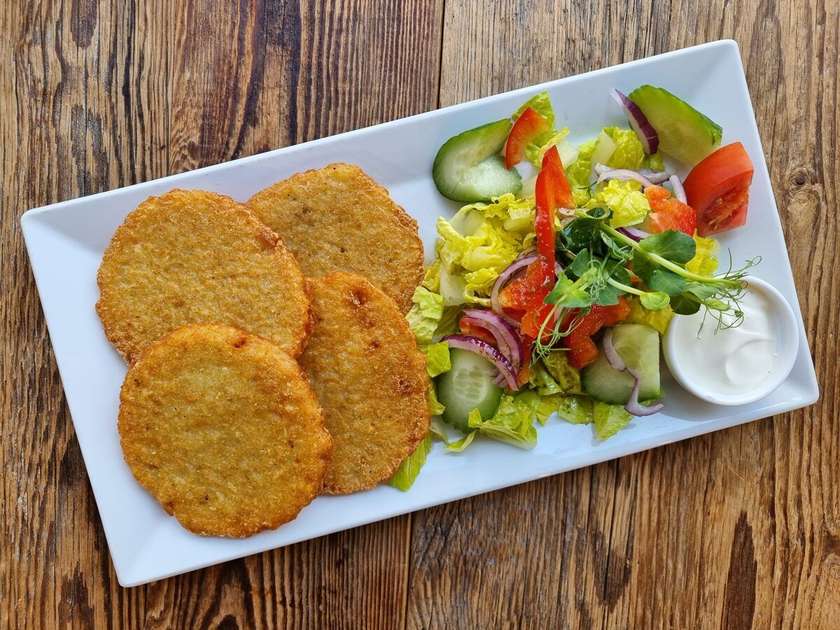 Potato pancakes with cream and salad
