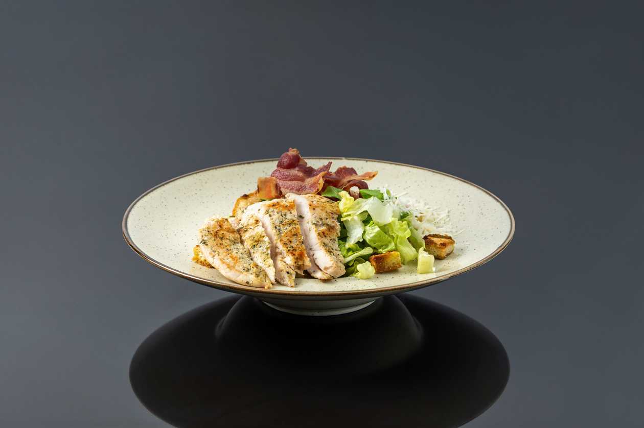 Caesar salad with chicken breast and bacon chips