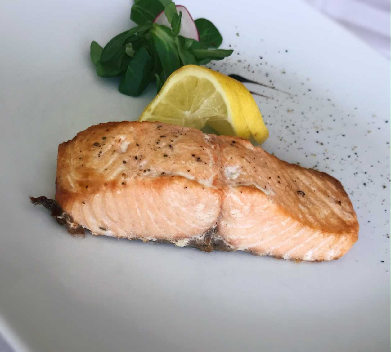 Alaskan salmon steak with colorful vegetable garnish