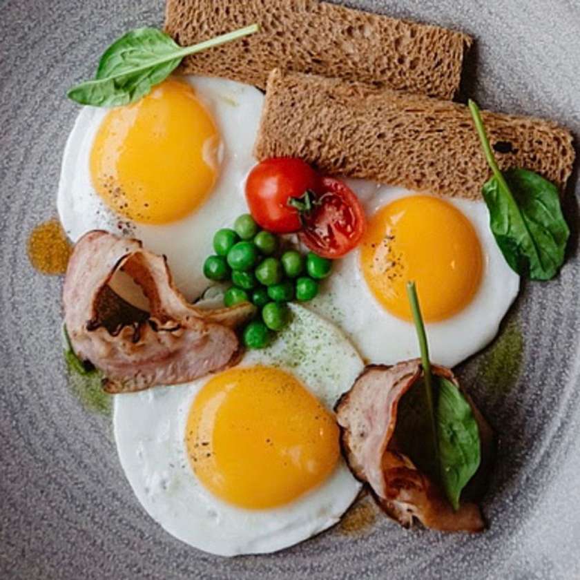 Sunny-side-up eggs (2 eggs) with bacon and tomato
