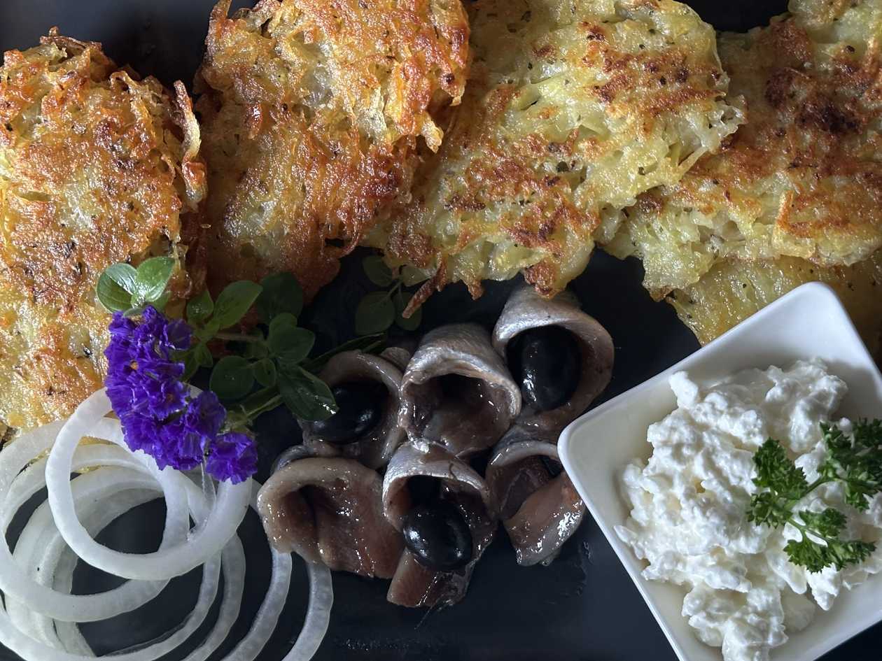 Potato pancakes with herring fillet in oil