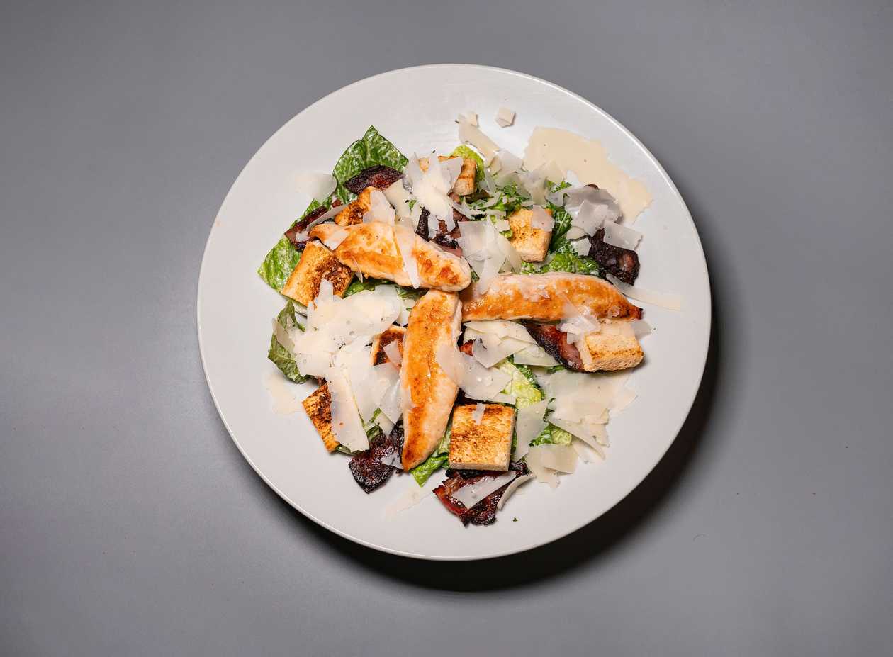 Caesar salad with chicken, English bacon, dressing and croutons