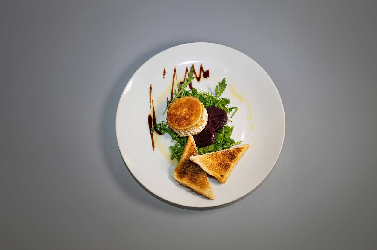 Grilled goat cheese with marinated beetroot and arugula, baked toast