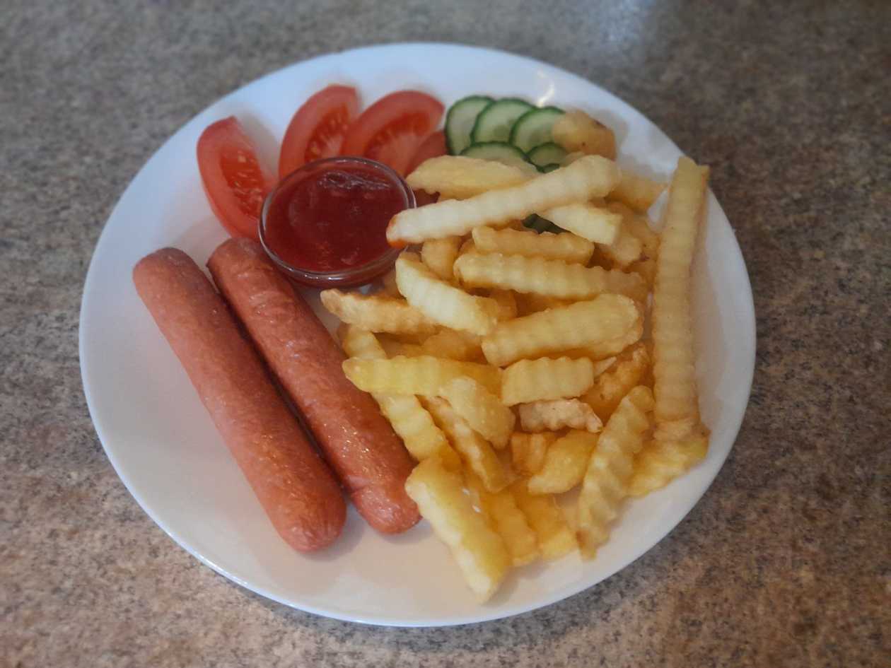French fries with milk sausages, tomatoes and cucumber