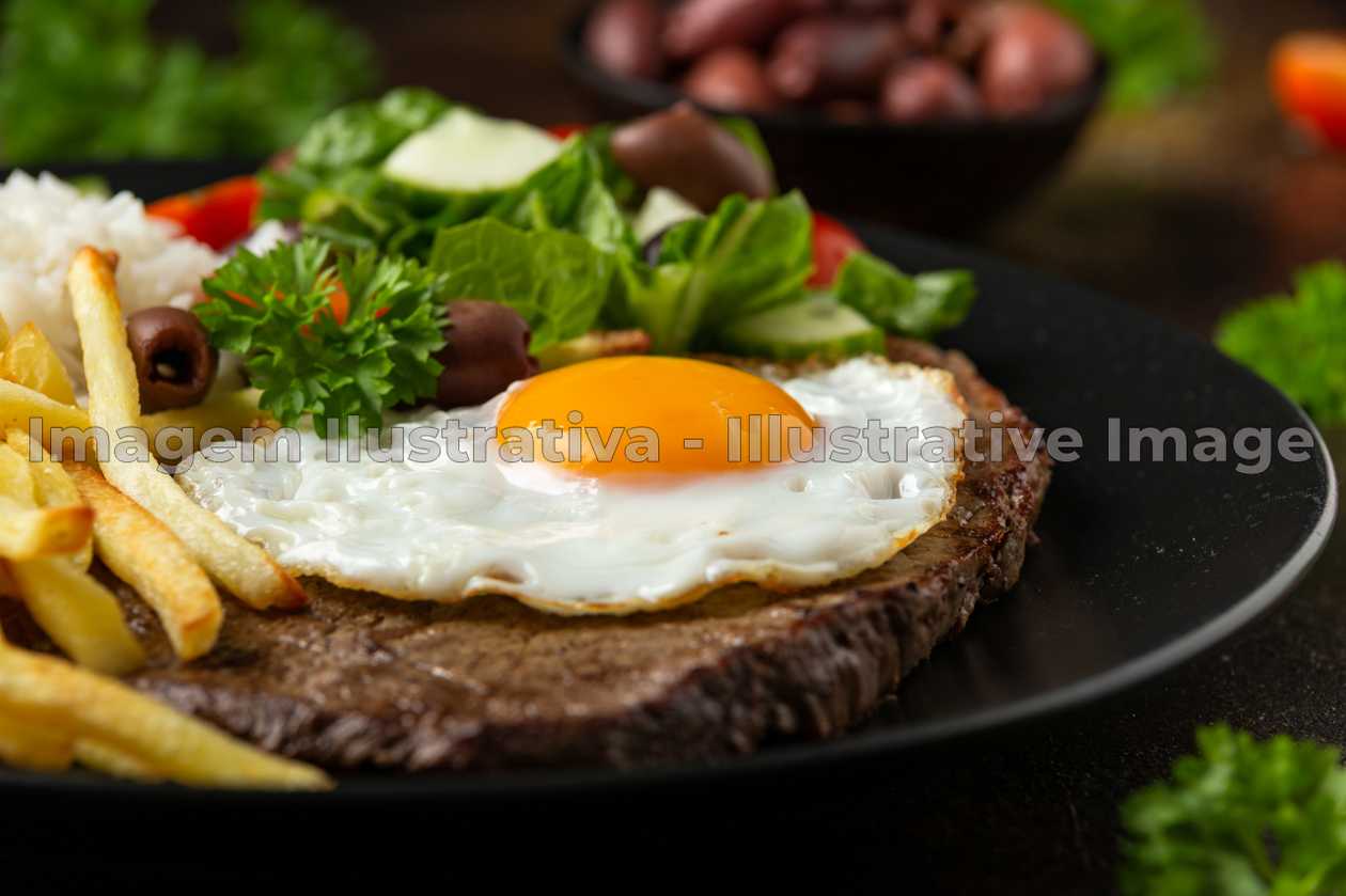 Steak with a fried egg and fries.
