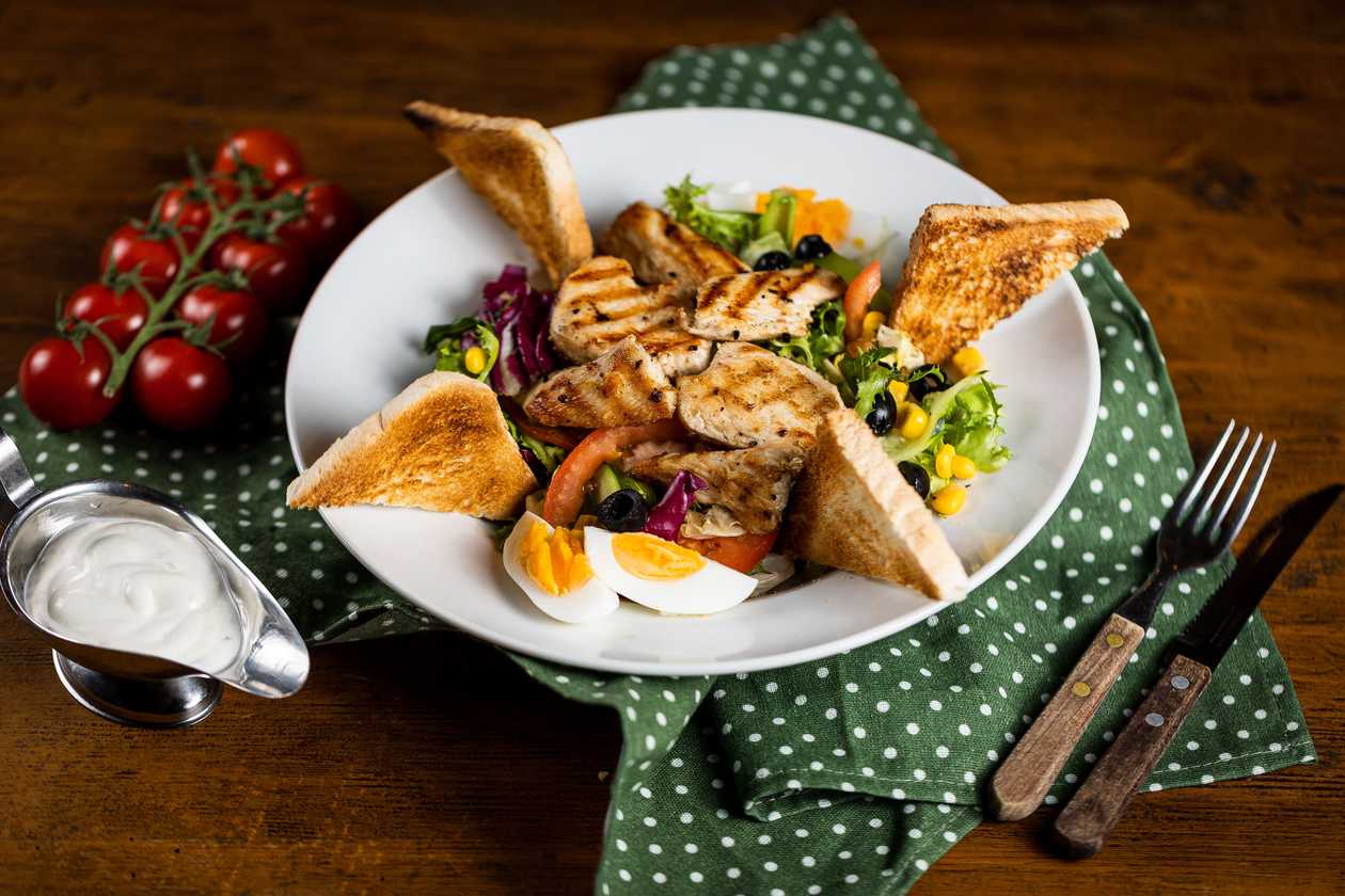 Vegetable salad with grilled chicken nuggets, toast