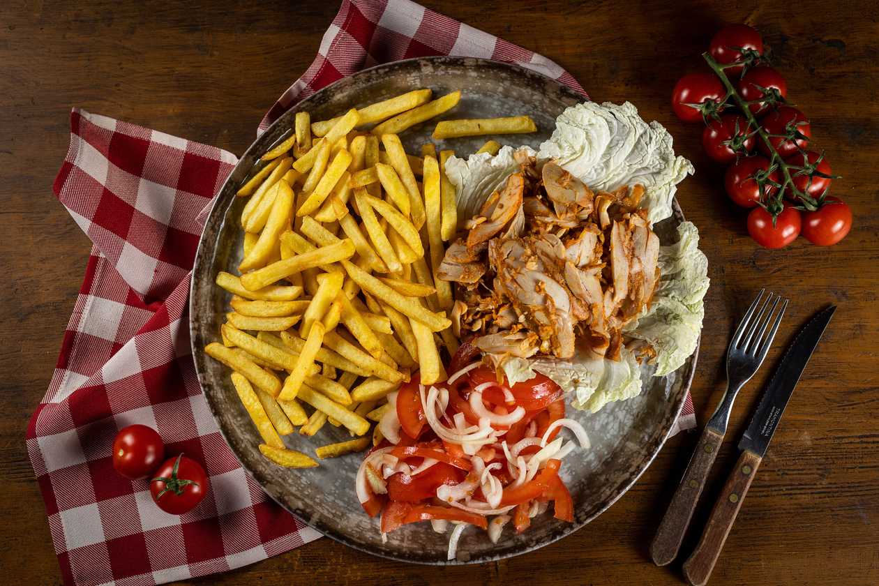 Kebab meat, fries, tomato and onion salad