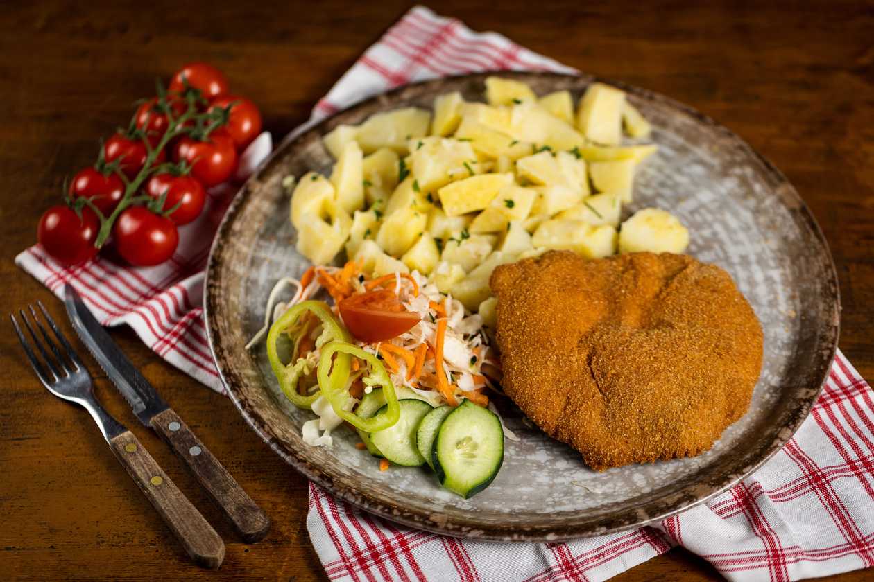 Fried chicken schnitzel, cooked potatoes, vegetable garnish