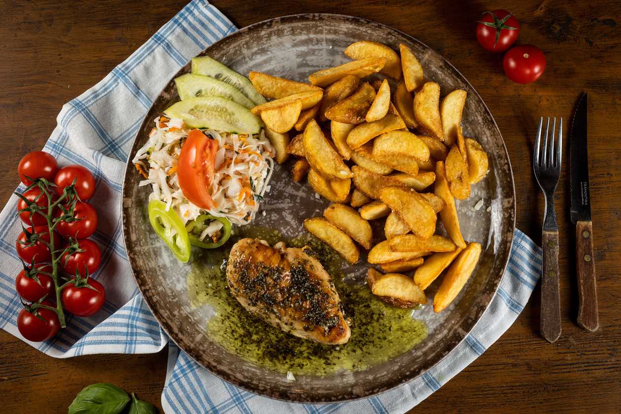 Chicken steak on herb butter, baked potatoes, vegetable garnish