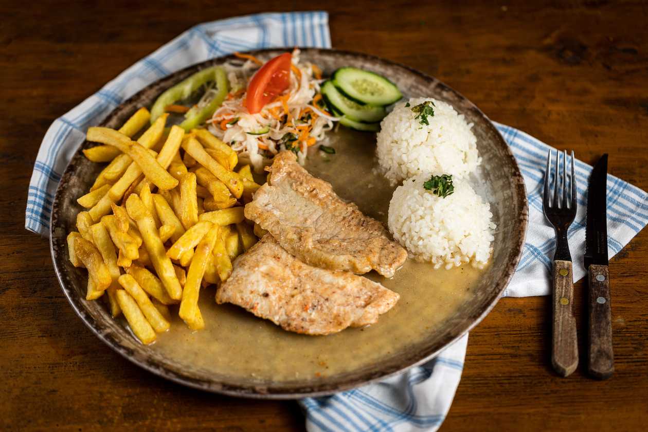 Natural pork schnitzel, 1/2 rice, 1/2 fries, vegetable garnish