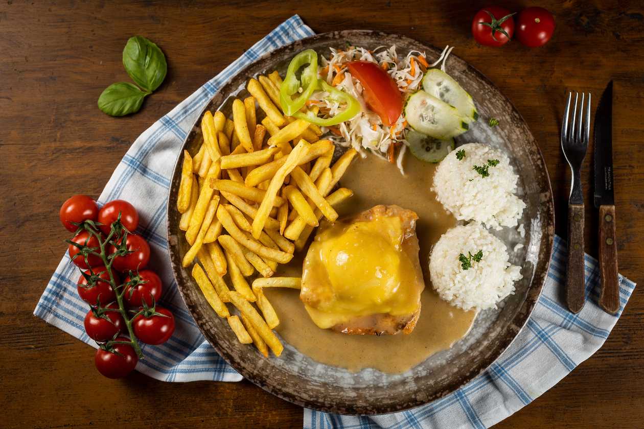 Natural chicken schnitzel with peach and cheese, 1/2 rice, 1/2 fries, vegetable garnish