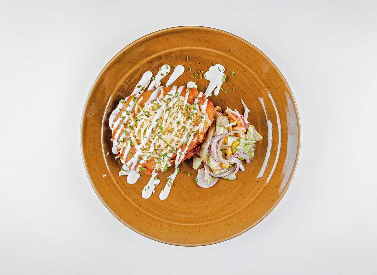 Chicken Montenegrin schnitzel topped with smoked cheese, seasonal vegetable salad
