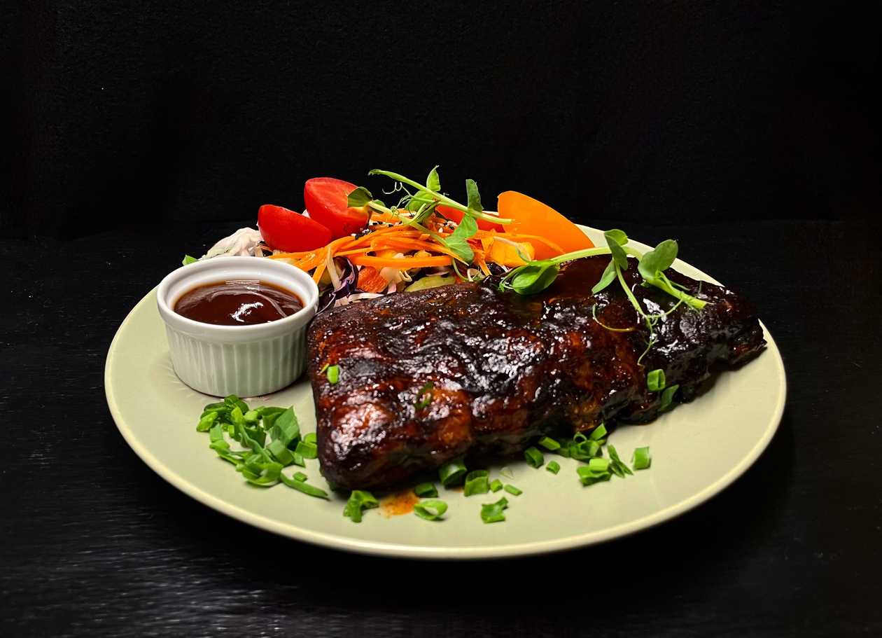 Oven-baked pork ribs with potato fries, pickled onions and BBQ-honey sauce