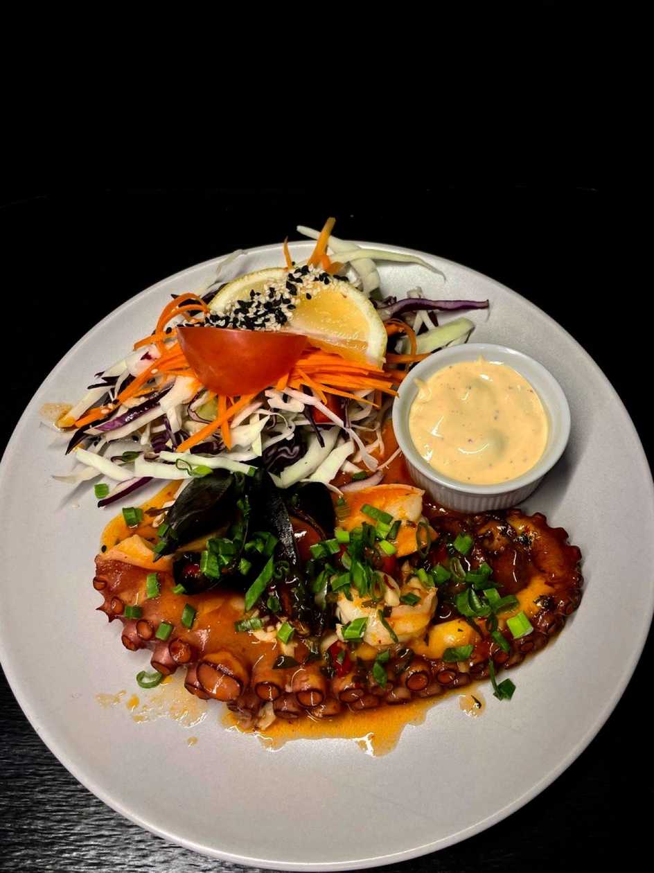 Octopus in green-garlic marinade, served with potato-cheese gratin and caper sauce