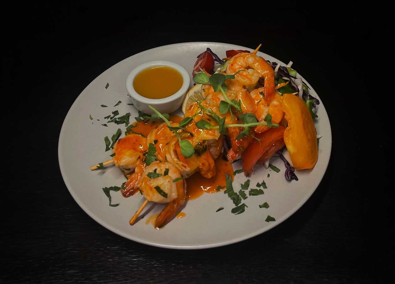 Tiger prawns marinated in Mediterranean spices with sweet potato fries and mango sauce