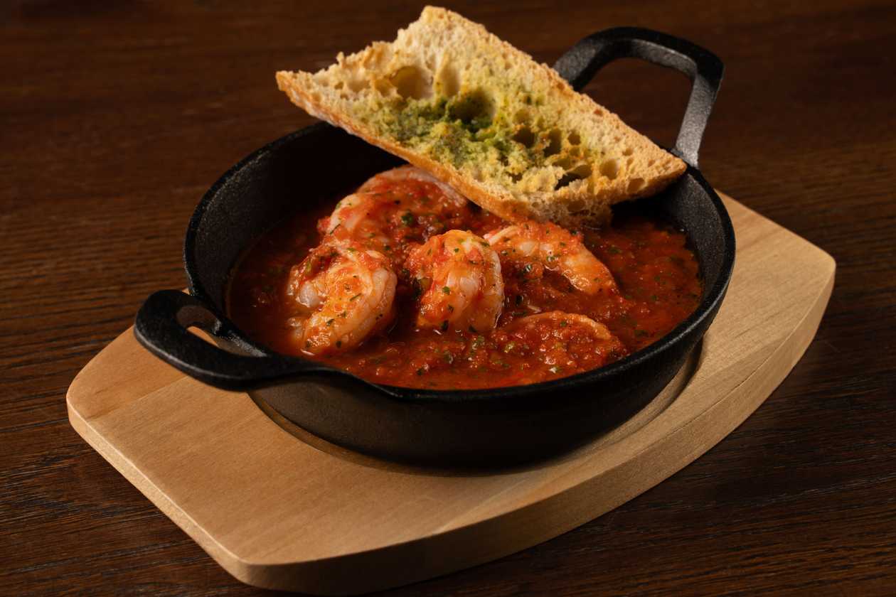 Tiger prawns in spicy tomato sauce with baguette