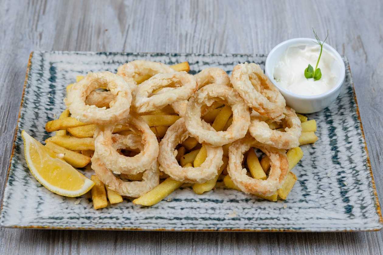 Calamari on a bed of potatoes with allioli sauce