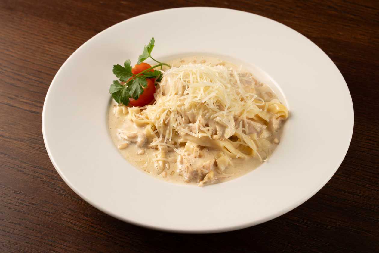 Pasta tagliatelle with slow cooked chicken fillet, hard cheese and pine nuts