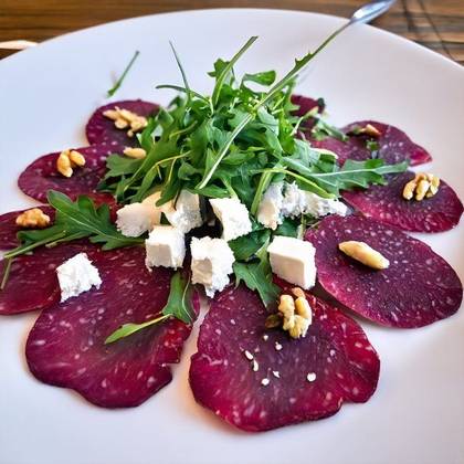 Beetroot carpaccio with goat cheese, nuts, arugula, prosciutto, baguette, balsamic reduction