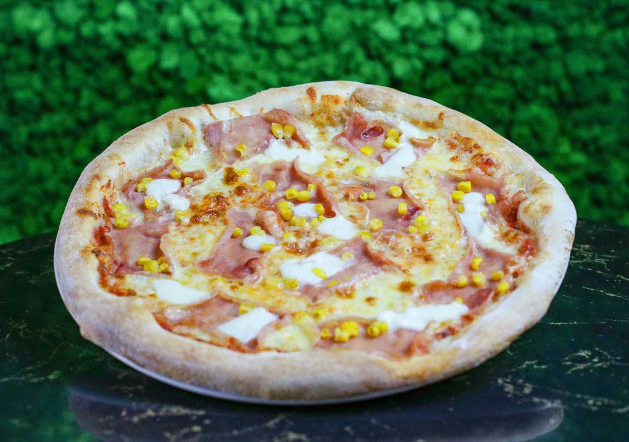 Pizza with prosciutto cotto and corn
