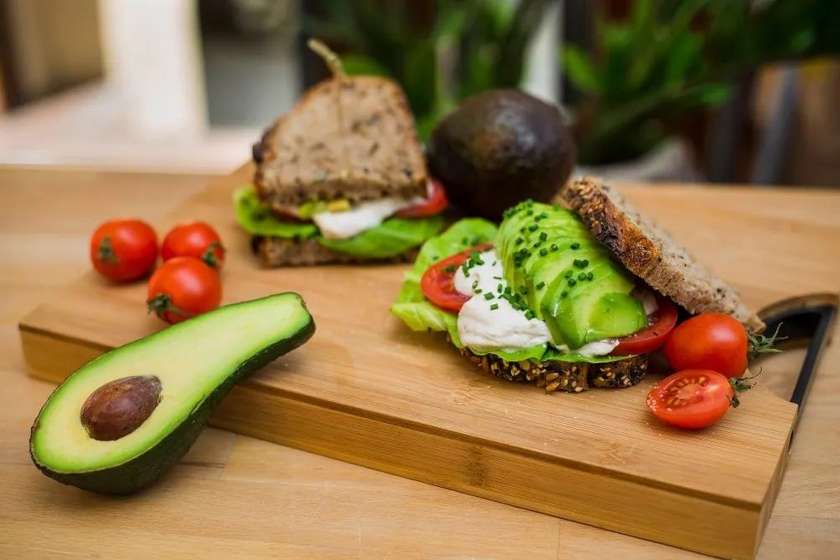 Sandwich proteic din pâine cu maia, avocado, salată, roșii și brânză casei