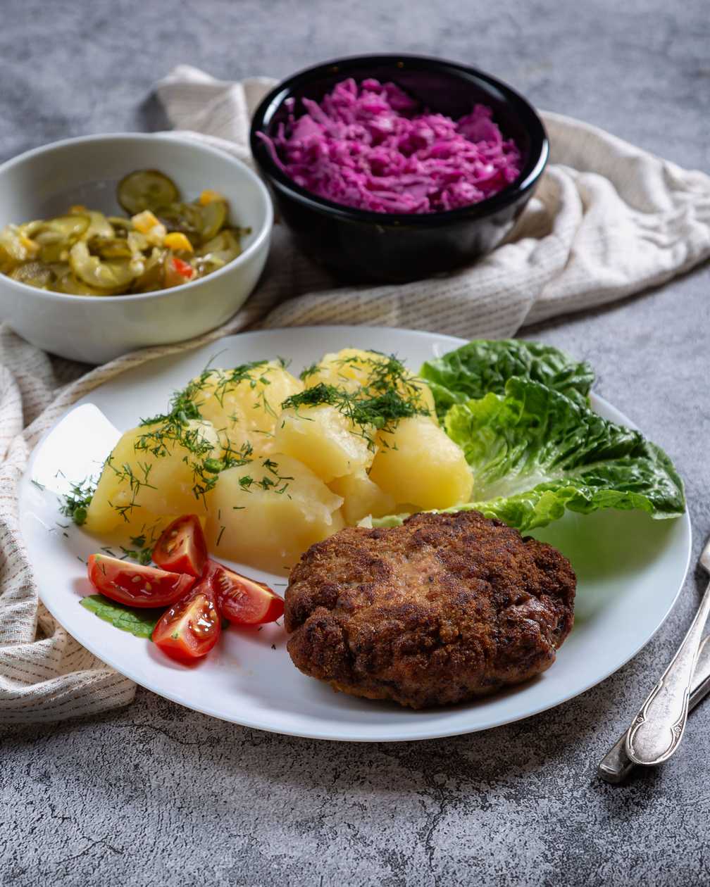 Minced meat (2 chops) served with potatoes and seasonal salad