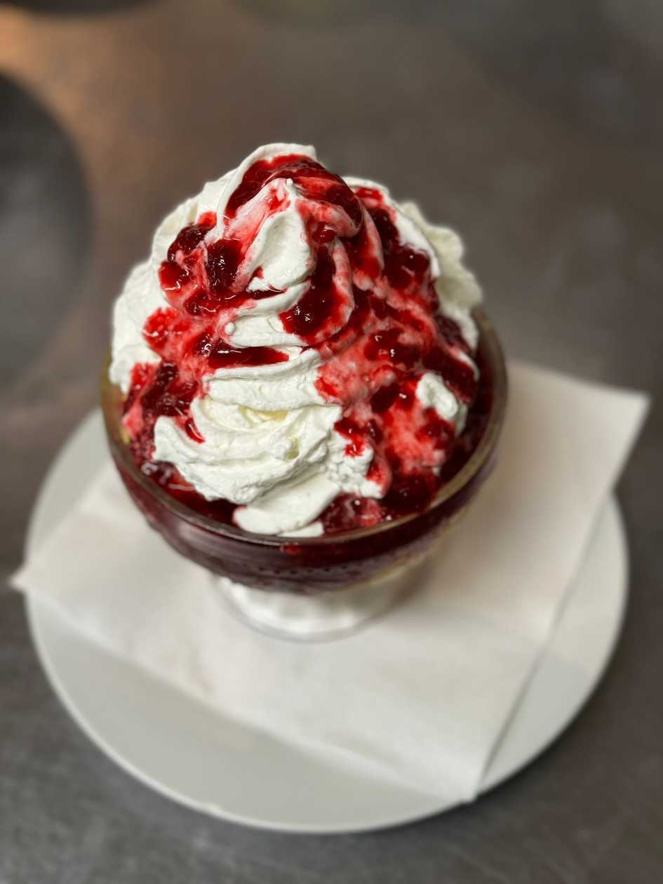 Hot raspberries with vanilla ice cream and whipped cream