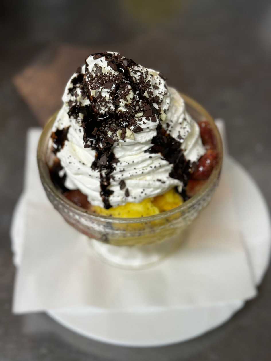 Ice cream sundae with fruit, ice cream, and whipped cream