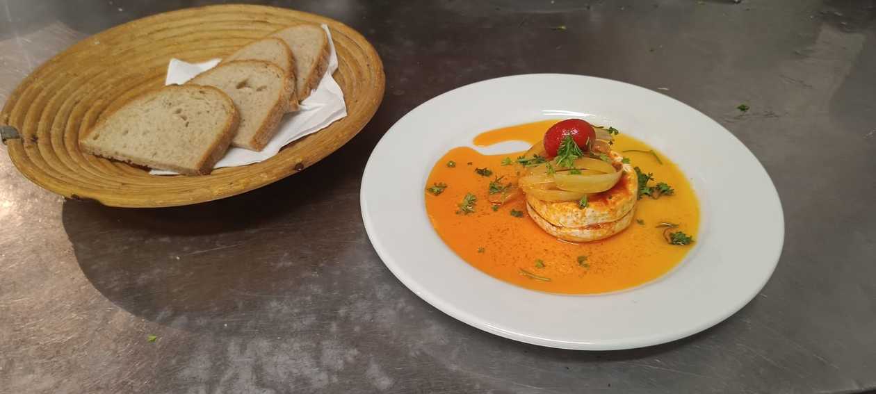 Homemade marinated camembert cheese with garlic, onion, and chilli pepper, served with bread