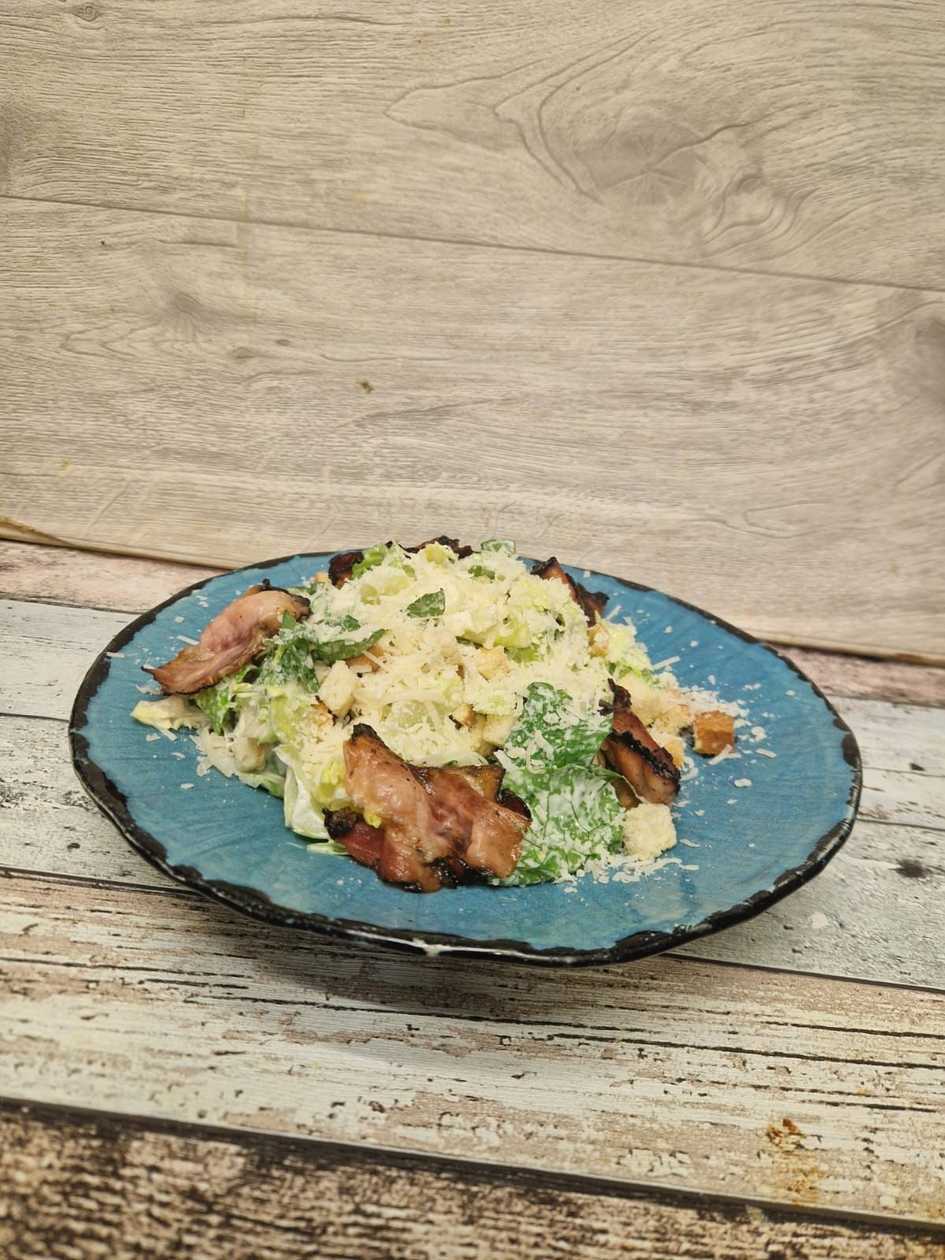 Caesar salad with slices of toasted bacon