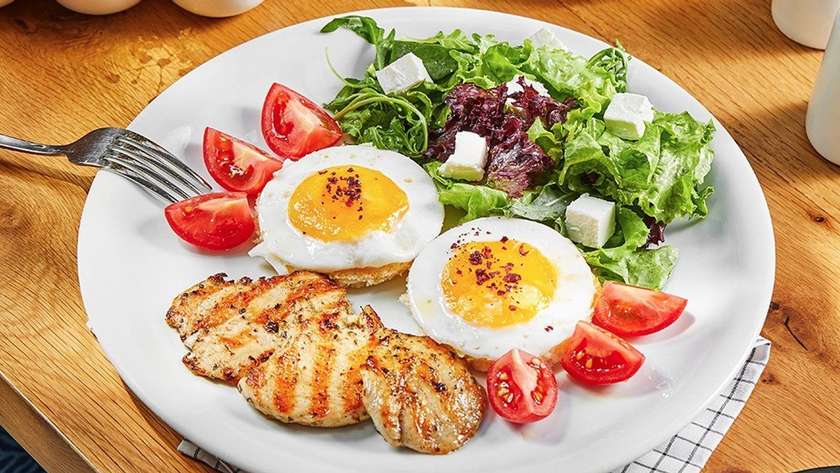 Fried eggs with chicken and salad