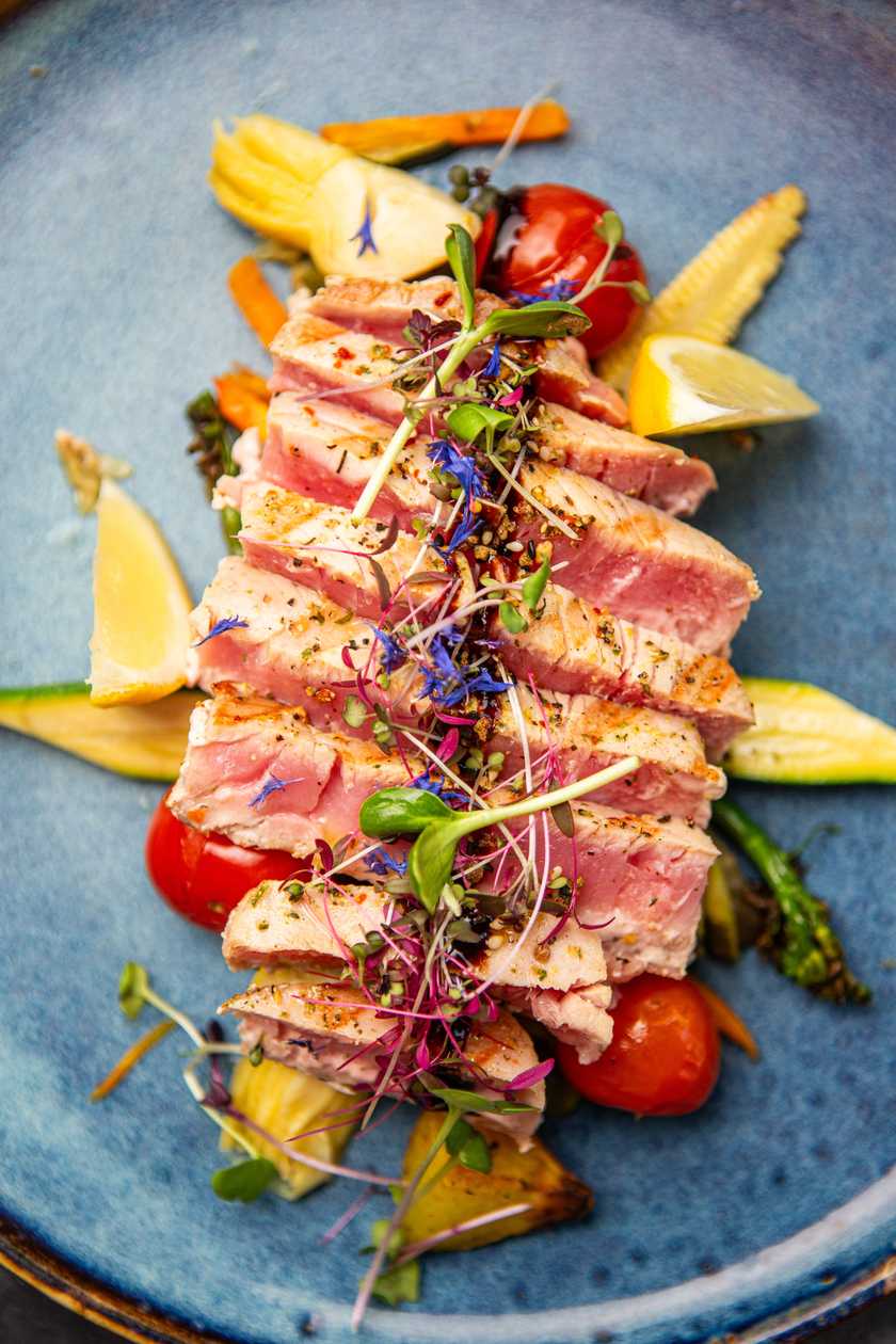 Grilled tuna steak with fried potatoes and cherry tomatoes