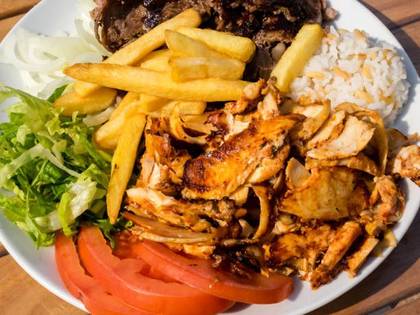 Kebab plate with potatoes, rice, and salad.