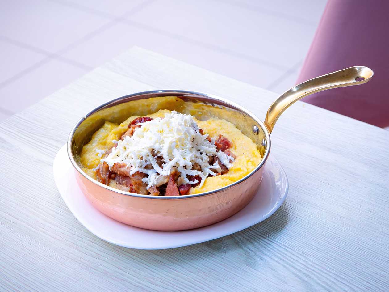 Meat in lard with polenta and grated telemea cheese