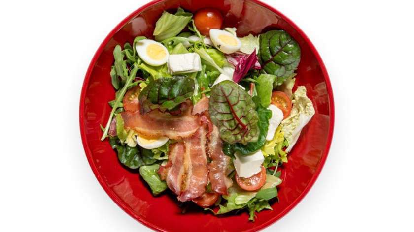 Salad with feta cheese, quail egg and bacon crisps