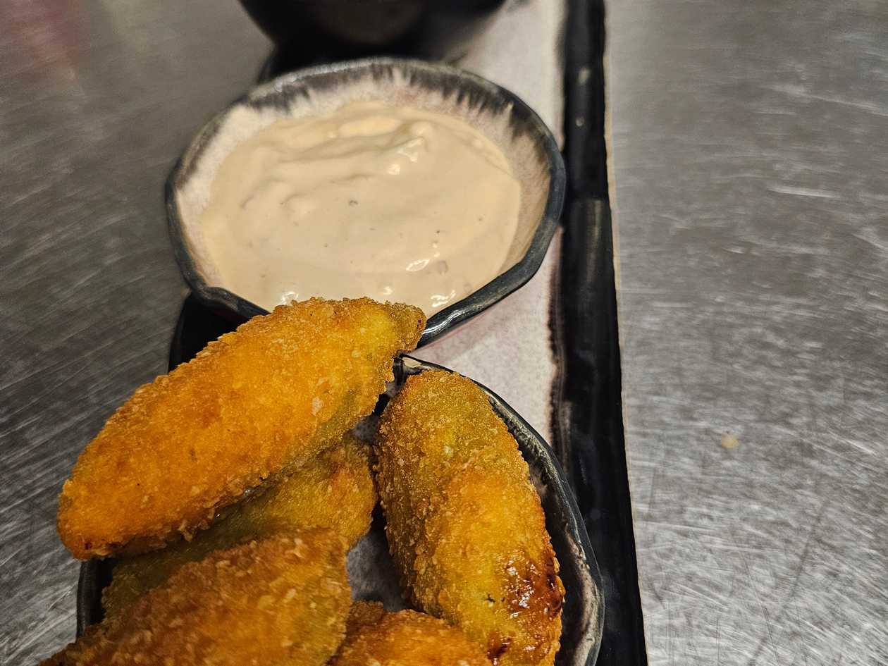 Fried jalapeňos stuffed cheddar cheese served with pikant dip and nachos