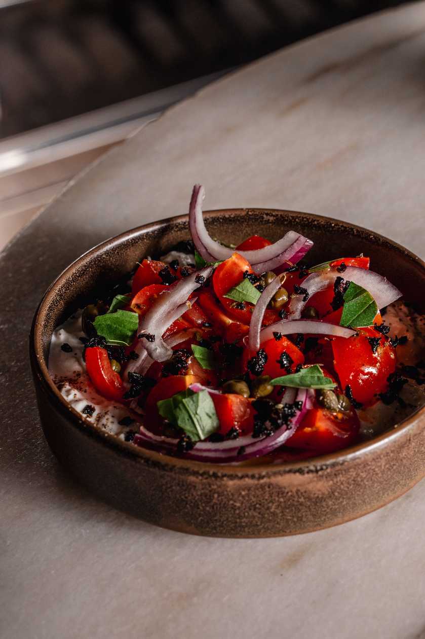 Stracciatella, cherry tomatoes, red onions, capers, olive granola, fruity balsamic sauce