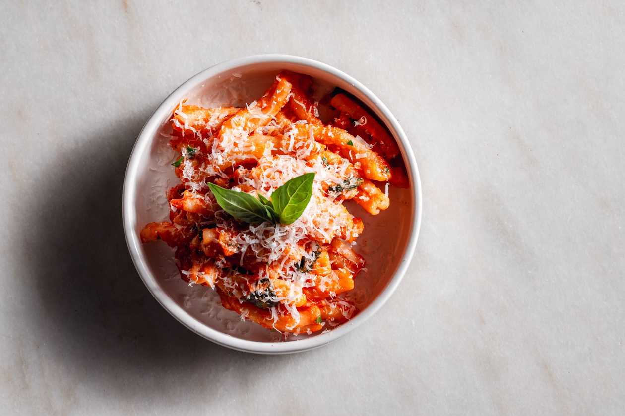 Casarecce pasta with arabiata sauce (spicy tomato sauce), parmesan and basil