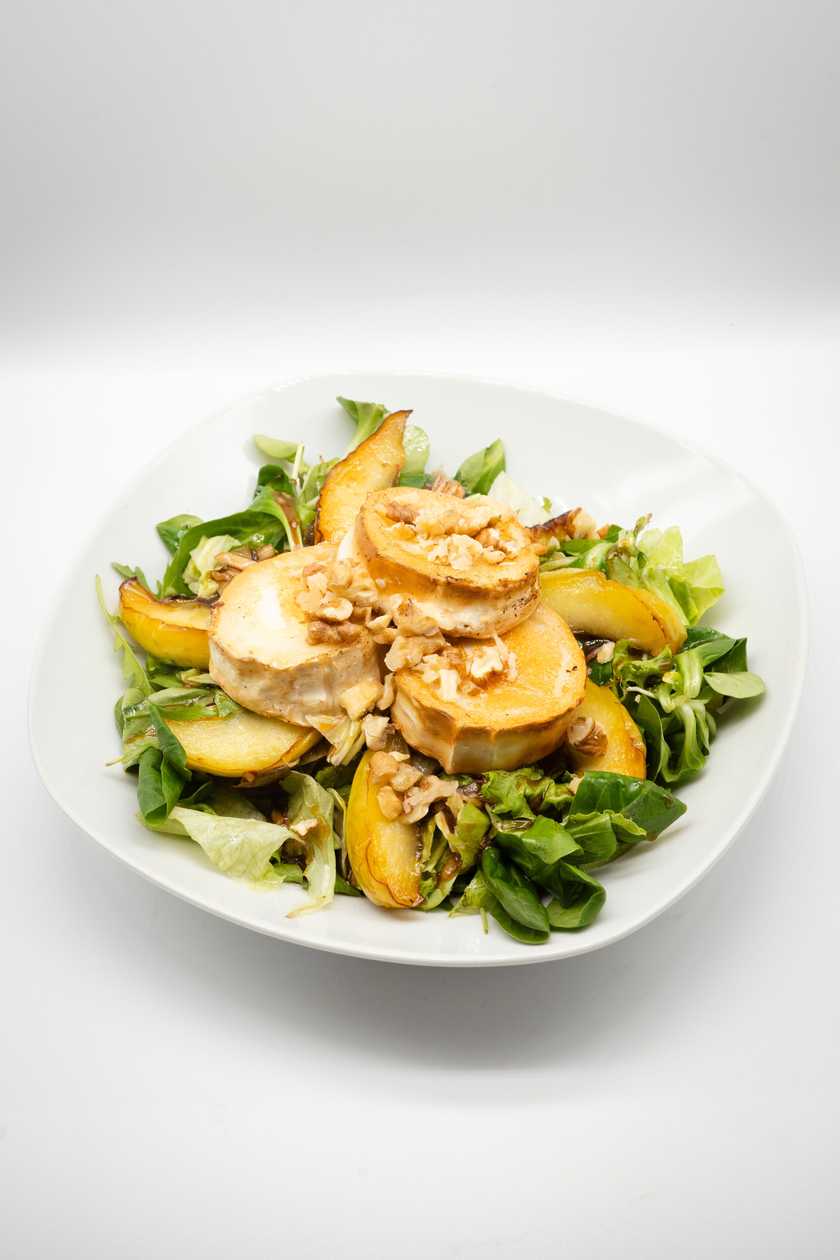 Leaf salad with grilled goat cheese, baked apples, cashews and balsamic-mint reduction