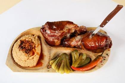 Pork Knuckle Served with Mashed Beans, Homemade Fries and Homemade Pickles